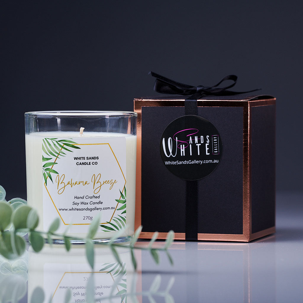 product photo of a soy wax candle in a clear jar with a black gift box tied with a black ribbon