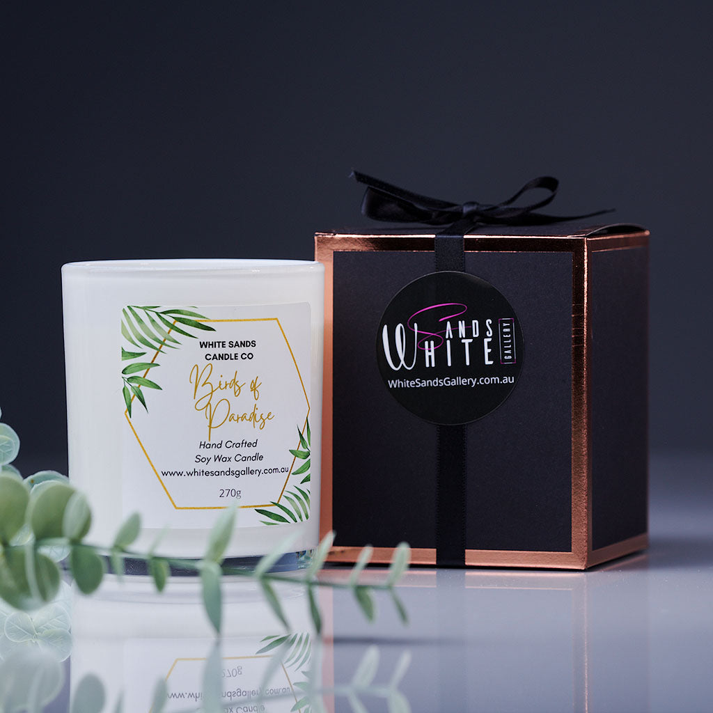 product photo of a soy wax candle in a clear jar with a black gift box tied with a black ribbon