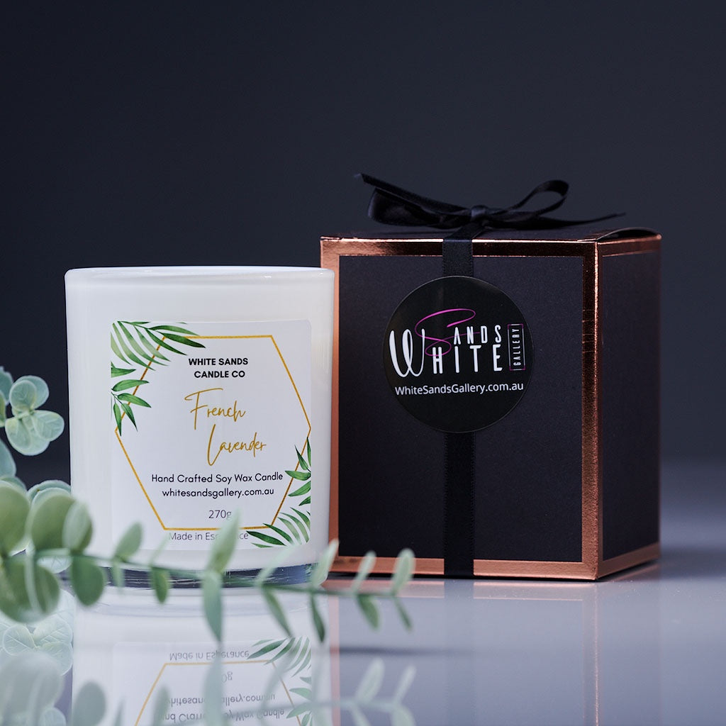 product photo of a soy wax candle in a clear jar with a black gift box tied with a black ribbon