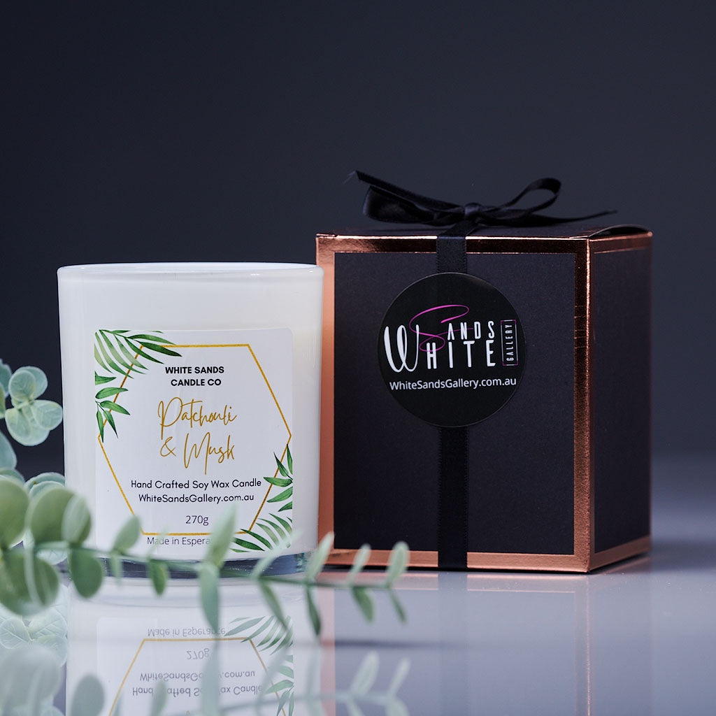 product photo of a soy wax candle in a white jar with a black gift box tied with a black ribbon