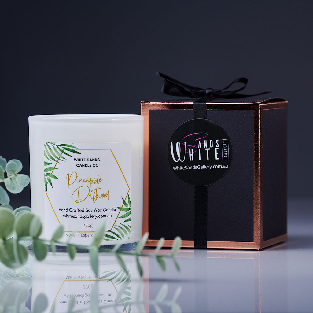 product photo of a soy wax candle in a white jar with a black gift box tied with a black ribbon