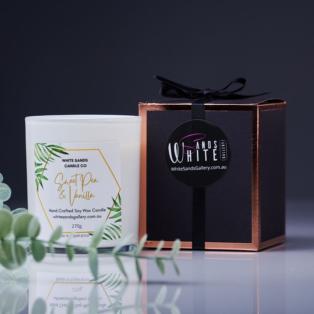 product photo of a soy wax candle in a white jar with a black gift box tied with a black ribbon