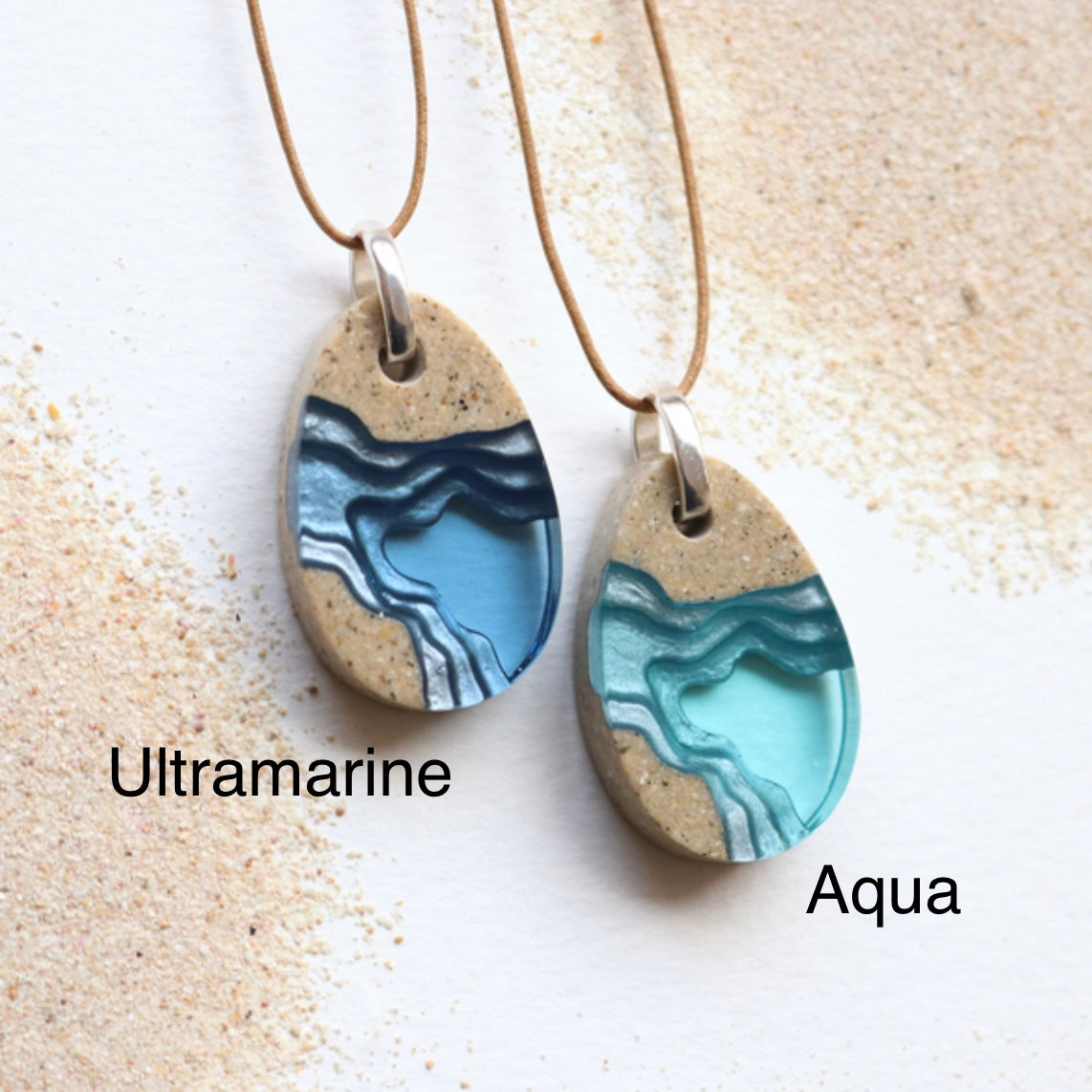 BoldB necklace sand and resin in a teardrop shaped pendant on a brown cord two colours blue and aqua