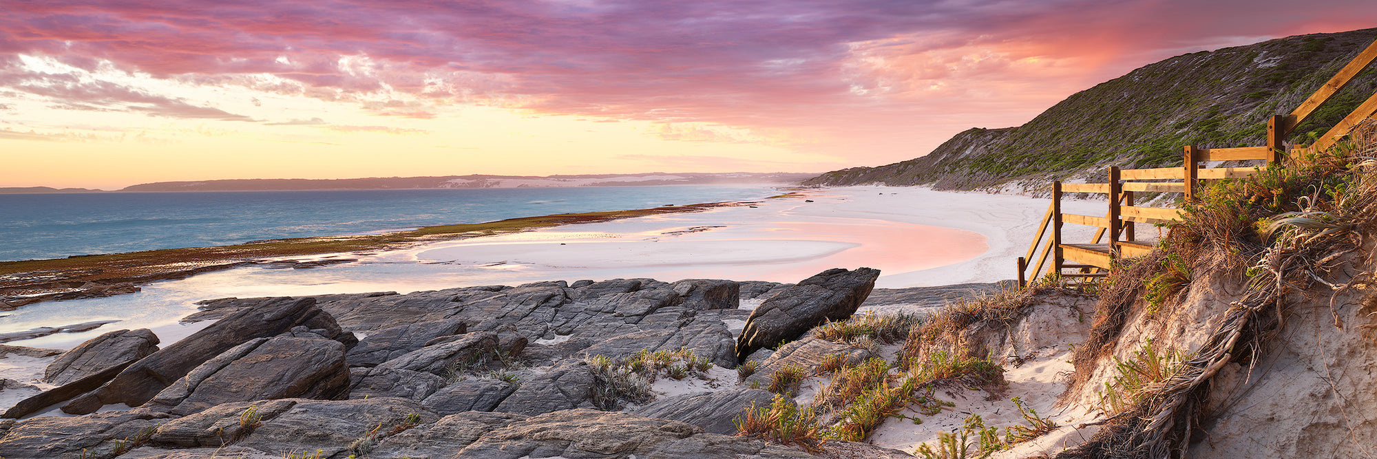 Eleven Mile beach summer evening rocky foreground with pink sky Esperance panorama