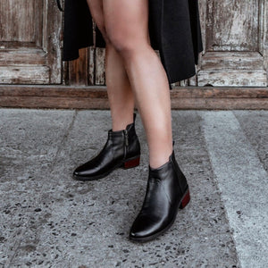 Model wearing Black leather wool lined waterproof ankle boots with small wood look heel